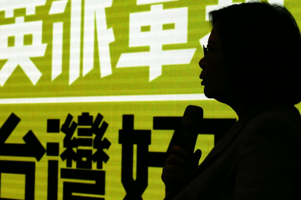 Taiwanese opposition leader and presidential candidate Tsai Ing-wen is silhouetted against a banner as she speaks during a news conference inside the Democratic Progressive Party headquarters in Taipei last month. Photo: EPA