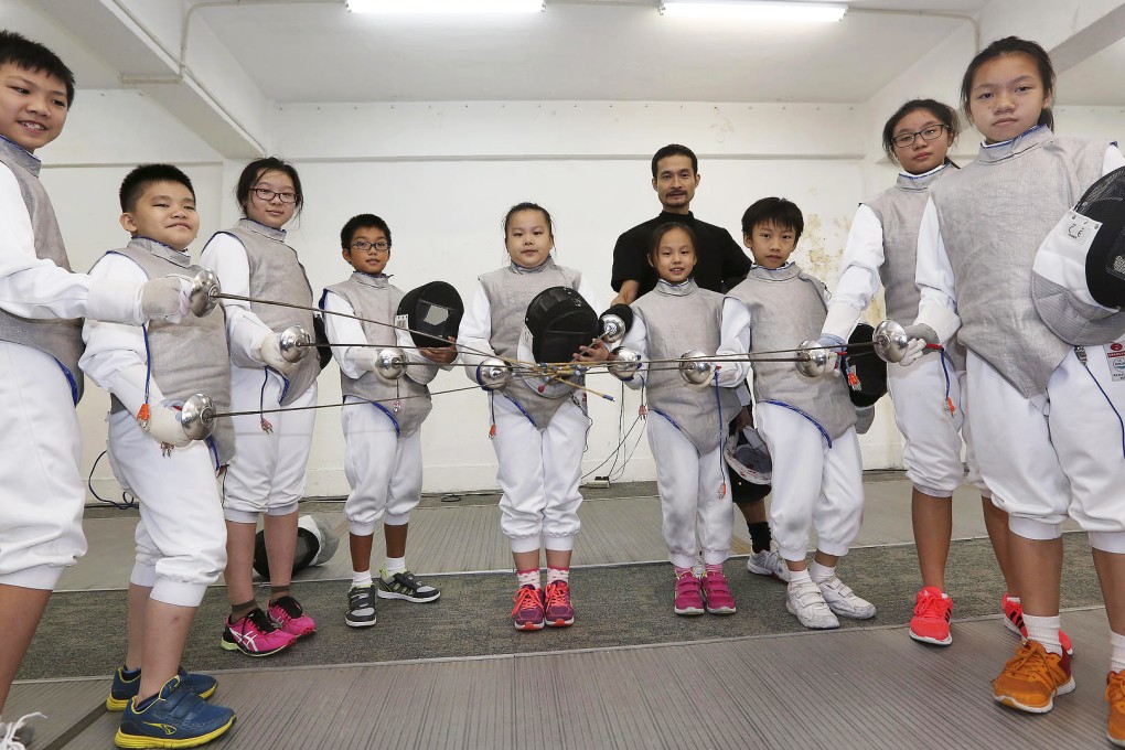 Coach Rolf Chow (in black) with his wards, including Poon Ip-yin (left). He hopes that fencing skills can give the children a sense of sportsmanship. Photo: Edward Wong