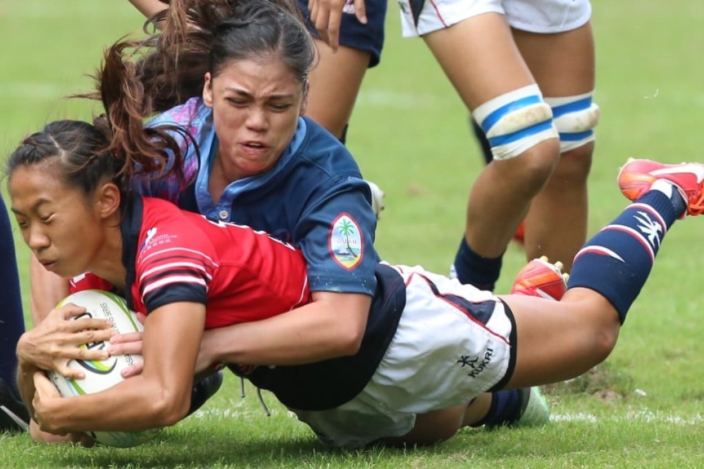 Hong Kong's Chong Ka-yan is tackled by Mariah Hennegan from Guam at Hong Kong Stadium on 8 November. Photo: KY Cheng/SCMP