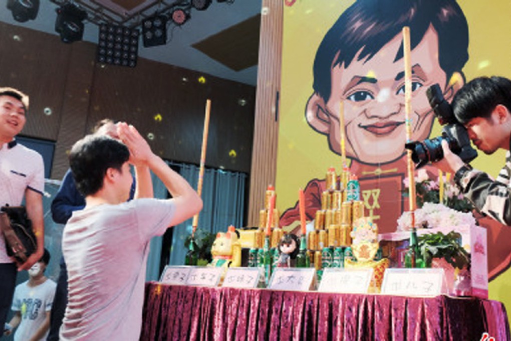 A man prays for a successful day's trading in front a cartoon image of Alibaba's chairman Jack Ma. Photos: SCMP Pictures