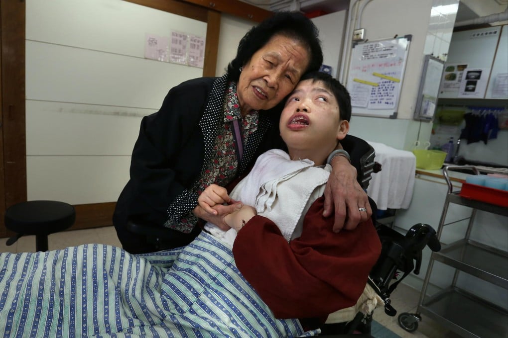 Tam Kwai-yuk comforts her daughter, Li Sze-yan, at the Lai Yiu Hostel. "My dream is for her to walk again," she says.Photo: Jonathan Wong