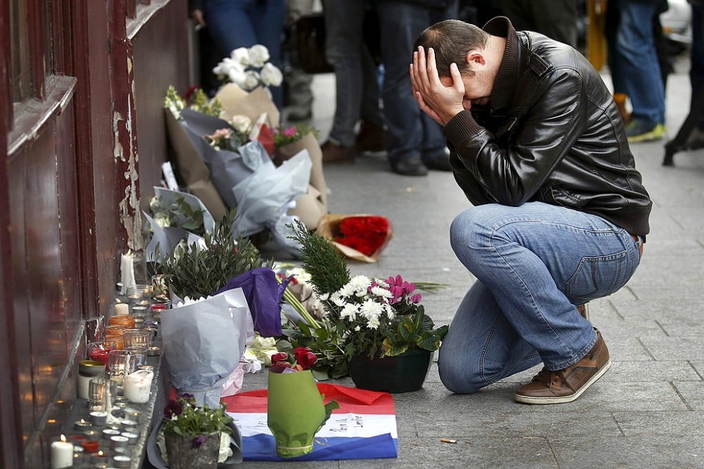 A man pays his respect outside the Le Carillon restaurant the morning after a series of deadly attacks in Paris. Photo: Reuters