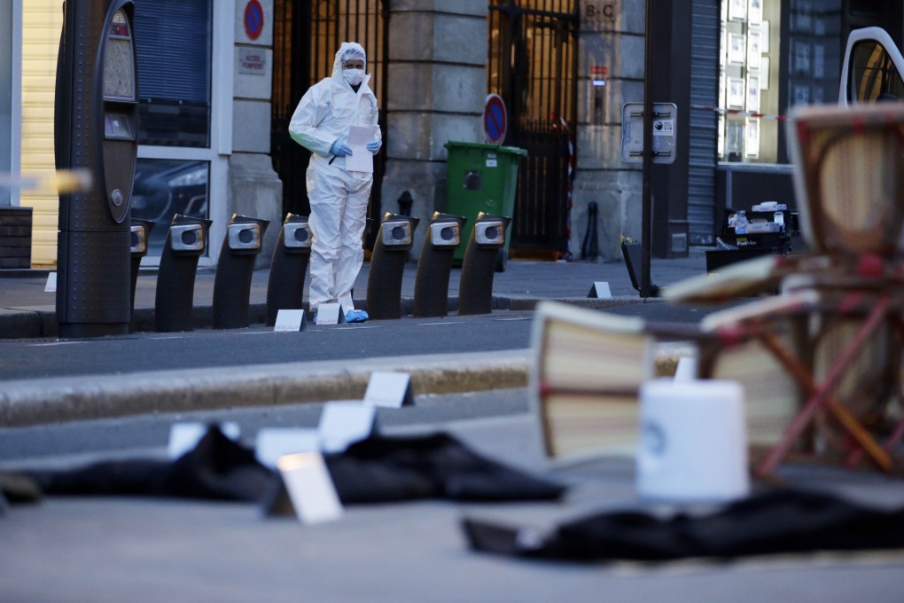 A forensic scientist inspects outside of the Cafe Bonne Biere on Rue du Faubourg du Temple in Paris following a series of coordinated attacks in and around Paris late Friday. photo: AFP