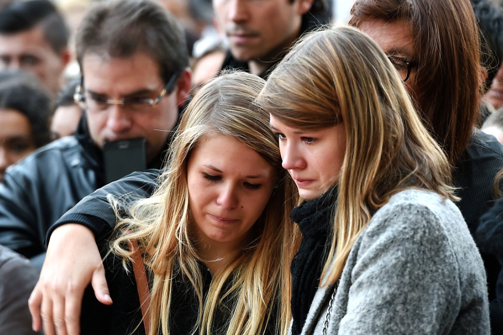 People mourn the dead at a makeshift memorial near the Bataclan concert hall in Paris, two days after a series of deadly attacks. Photo: AFP