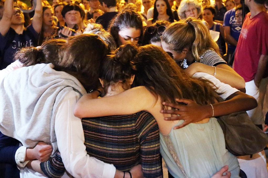 Participants hug together during a minute of silence during a vigil honoring the victims of the Paris attacks at Sun Yat Sen Memorial Park in Hong Kong. Photo: Edward Wong