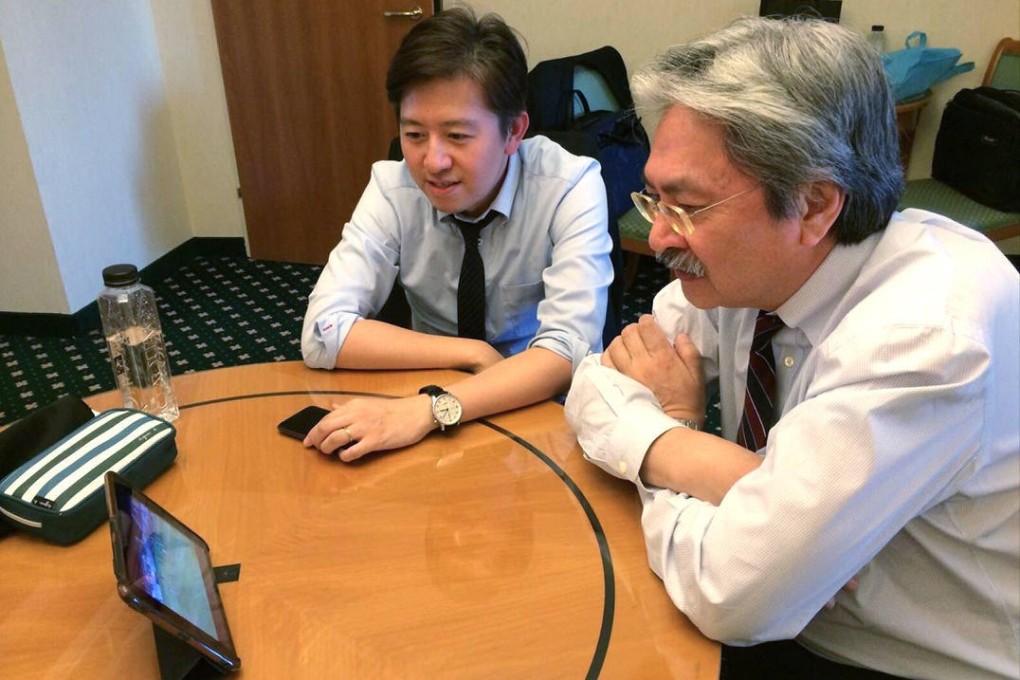 John Tsang watches the game with an aide. Photo: SCMP Picture
