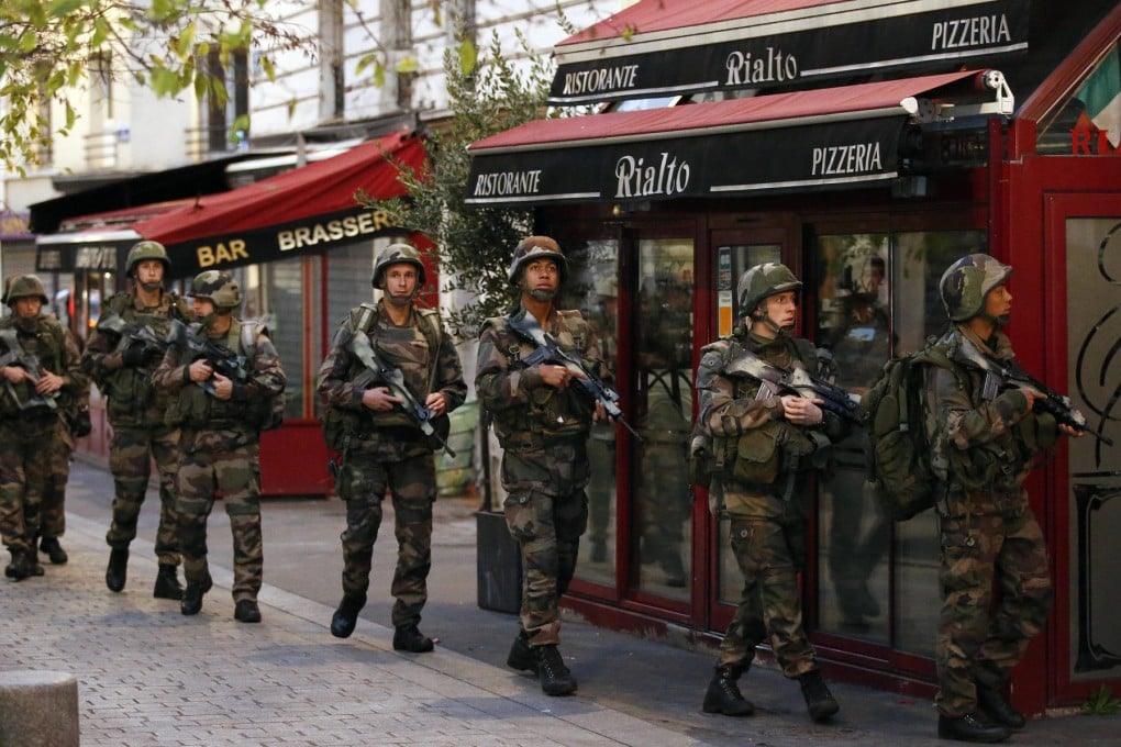 Soldiers move into position in St Denis, a northern suburb of Paris, during yesterday's counter-terror operation that led to the arrests of seven people. Photos: AP