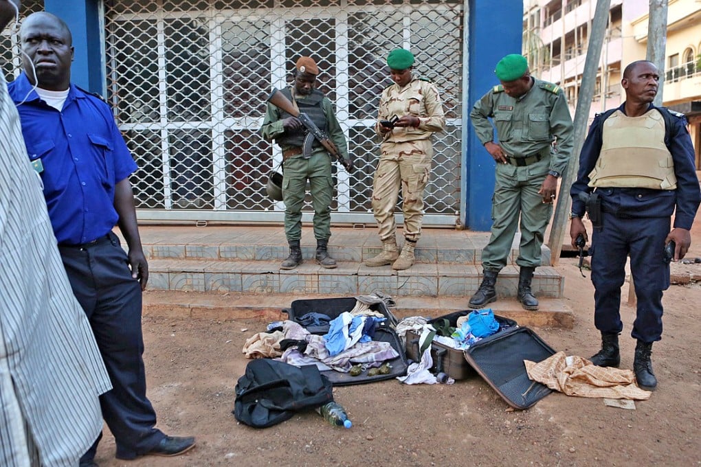 Malian soldiers display grenades and other supplies they said belonged to jihadists in front of the Radisson hotel in Bamako, Mali. Photo: Reuters