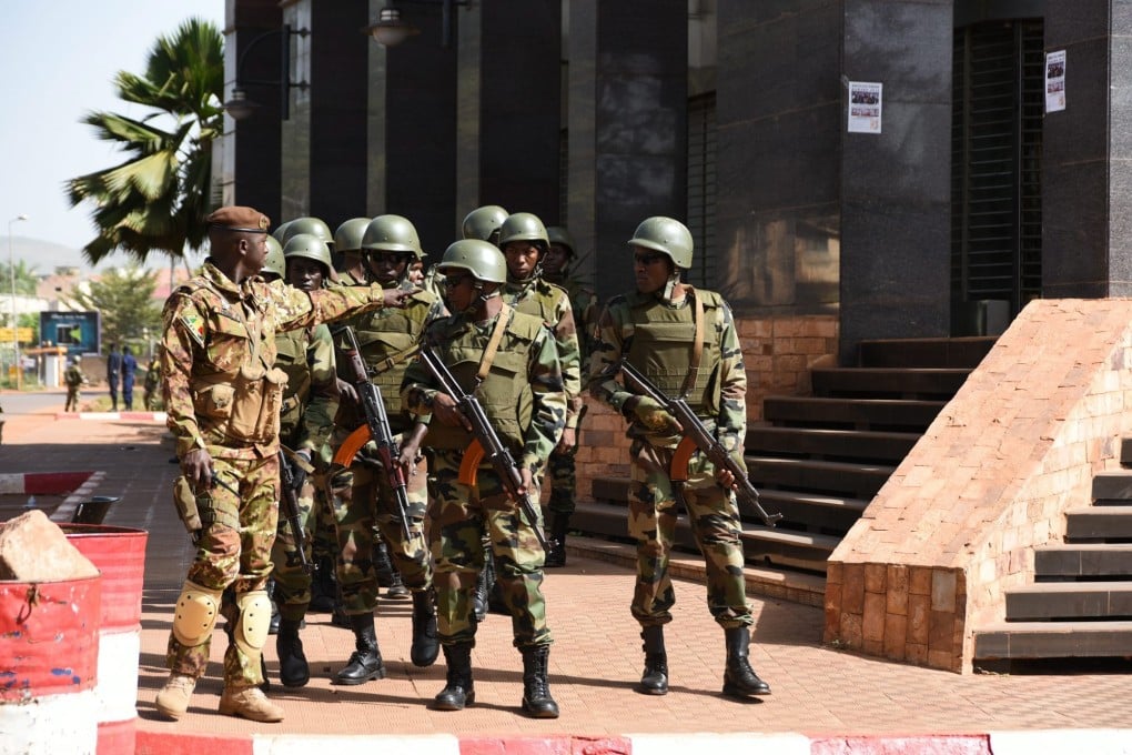 Malian soldiers stand guard outside the Radisson Hotel following a hostage situation a day earlier, in Bamako, Mali. Image: EPA