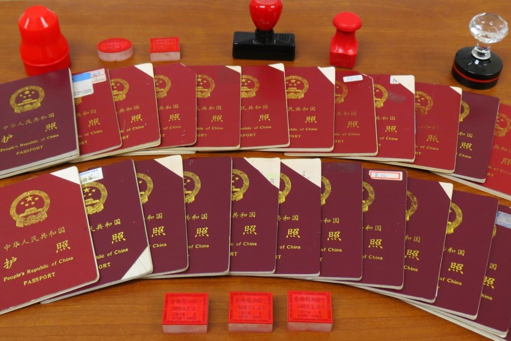 A photo released by the Canada Border Services Agency shows some of the doctored Chinese passports seized from the offices of Xun Wang, along with fake Chinese immigration stamps. Photo: CBSA