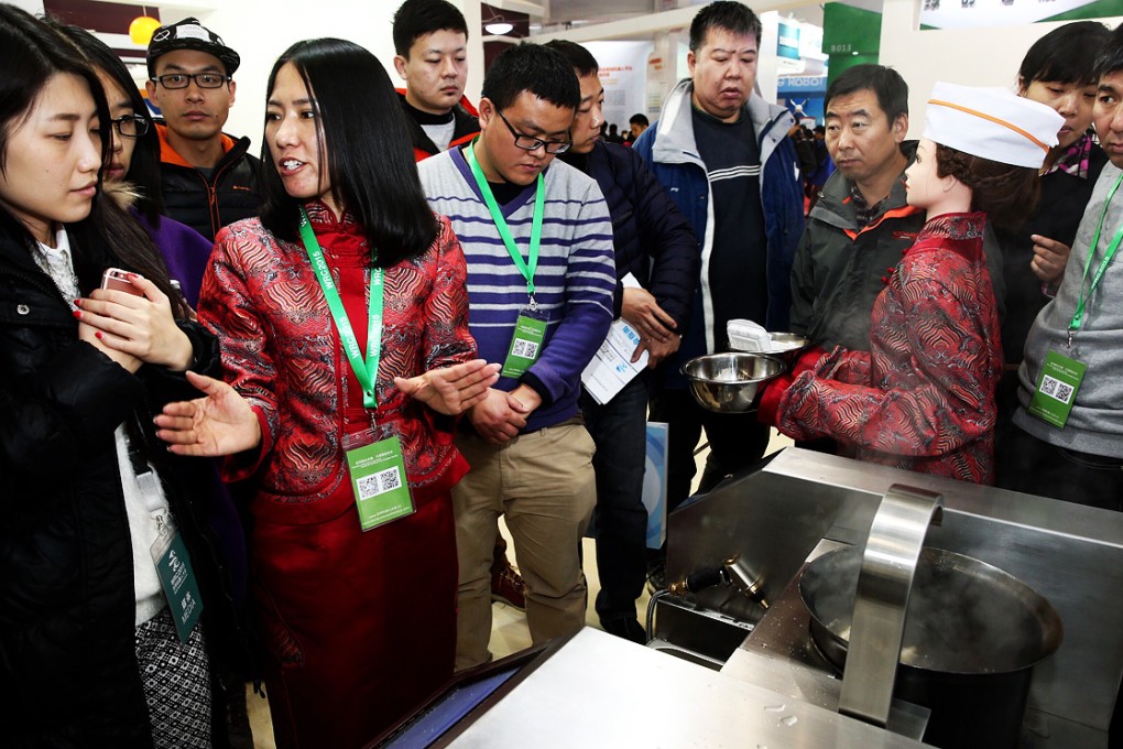 An exhibitor introduces a robot that can cook hundreds of dishes during the World Robot Conference in Beijing. Photo: Xinhua