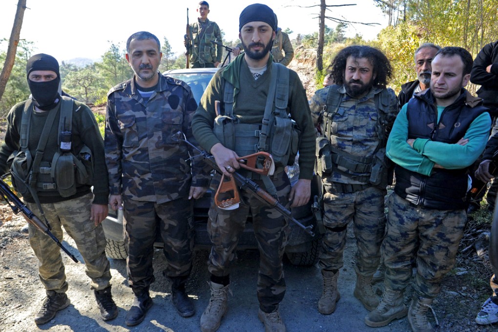 Alpaslan Celik (centre), a deputy commander in a Syrian Turkmen brigade, holds handles believed to be parts of a parachute that the pilots used. Photo: Reuters