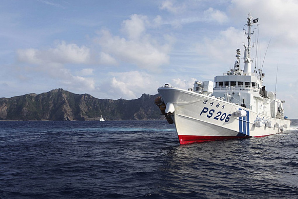 A Japan Coast Guard vessel sailing in front of one of the disputed islands in the East China Sea. Photo: Reuters