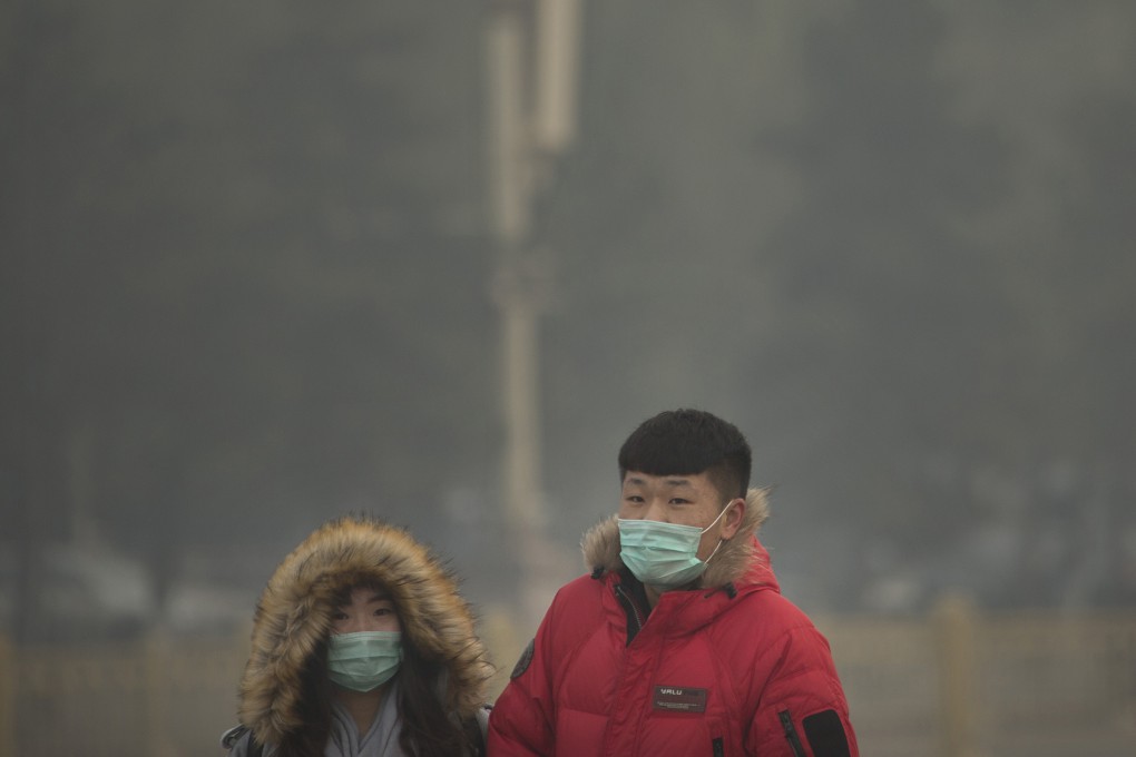 People wearing face masks walk across Tiananmen Square on a day with poor air quality in Beijing. Photo: AP