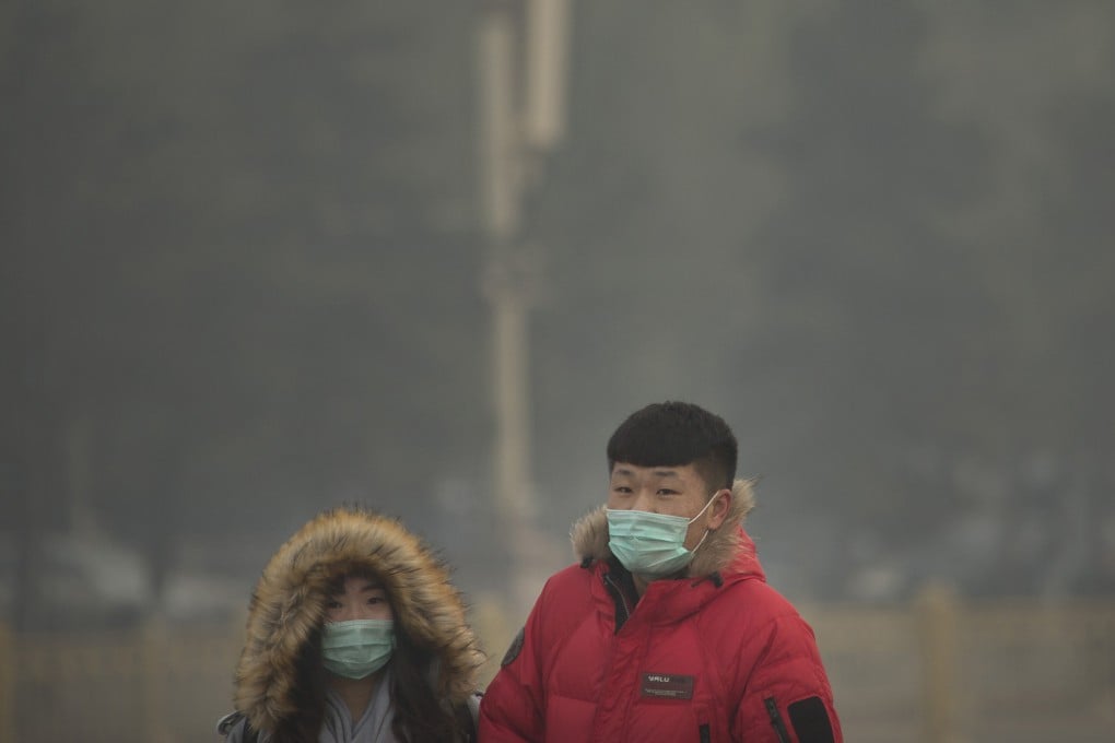 People wearing face masks walk across Tiananmen Square on a day with poor air quality in Beijing. Photo: AP