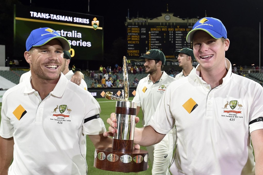 Australia captain Steve Smith (right) with teammate David Warner smile as they walk back with the Trans-Tasman trophy after defeating New Zealand in the first day-night cricket test match at the Adelaide Oval. Photo: AFP