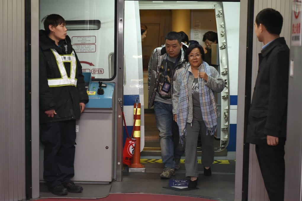 Huang Yurong, a former Communist Party head at the highway agency in China's Henan province, handed herself in on Saturday. Here she is pictured being taken into custody at Beijing Capital International Airport. Photo: Xinhua