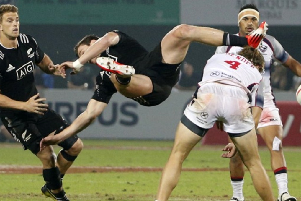 Sam Dickson of the All Blacks Sevens gets upended as he fights for the ball with USA player Garrett Bender during their pool game on the first day of the Dubai Sevens. The American won the match 14-12. Photos: AFP