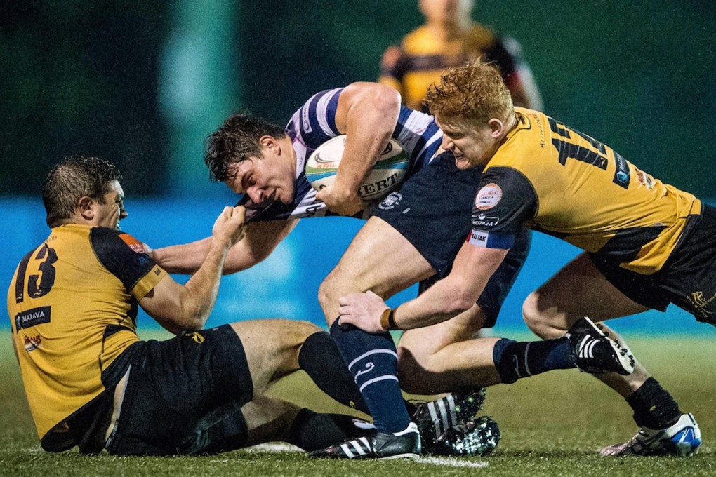 HKFC's Charles Higson-Smith gets wrapped up by the USRC Tigers centres at King's Park. Tigers won the match 24-18. Photos: HKRU