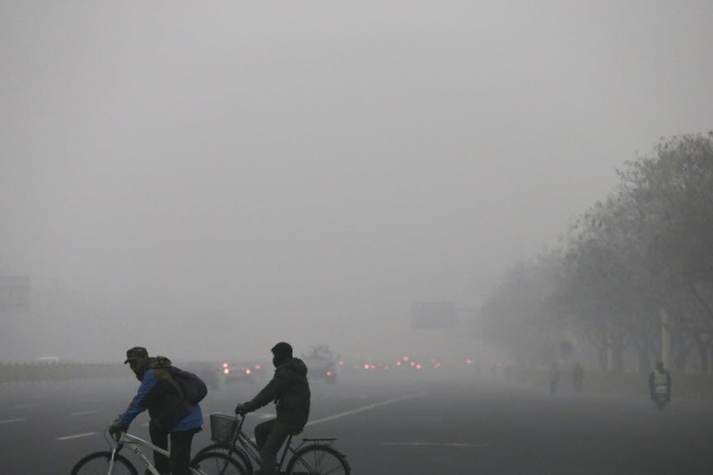 Cyclists brave the smog in the streets of the capital. Photo: AP