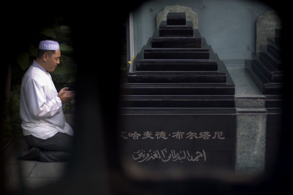 A Chinese Muslim offers prayers at the tomb site of two former Muslim imams during Eid ul-Fitr morning prayers at the Niujie mosque, the oldest and largest mosque in Beijing. Photo: AP