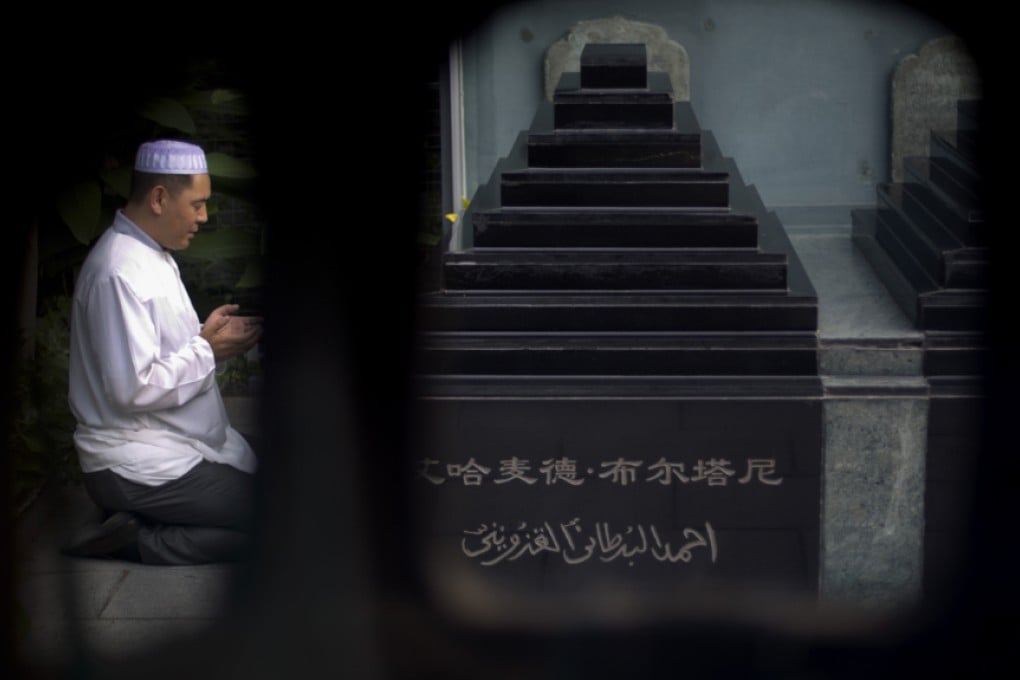 A Chinese Muslim offers prayers at the tomb site of two former Muslim imams during Eid ul-Fitr morning prayers at the Niujie mosque, the oldest and largest mosque in Beijing. Photo: AP