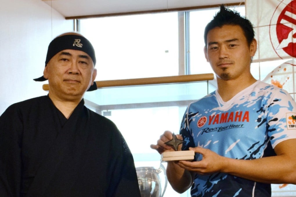 Japanese fullback Ayumu Goromaru receives his “Master of Ninjas” award from a Japan Ninja Council official in Iwata, Shizuoka prefecture on Wednesday. Photo: AFP