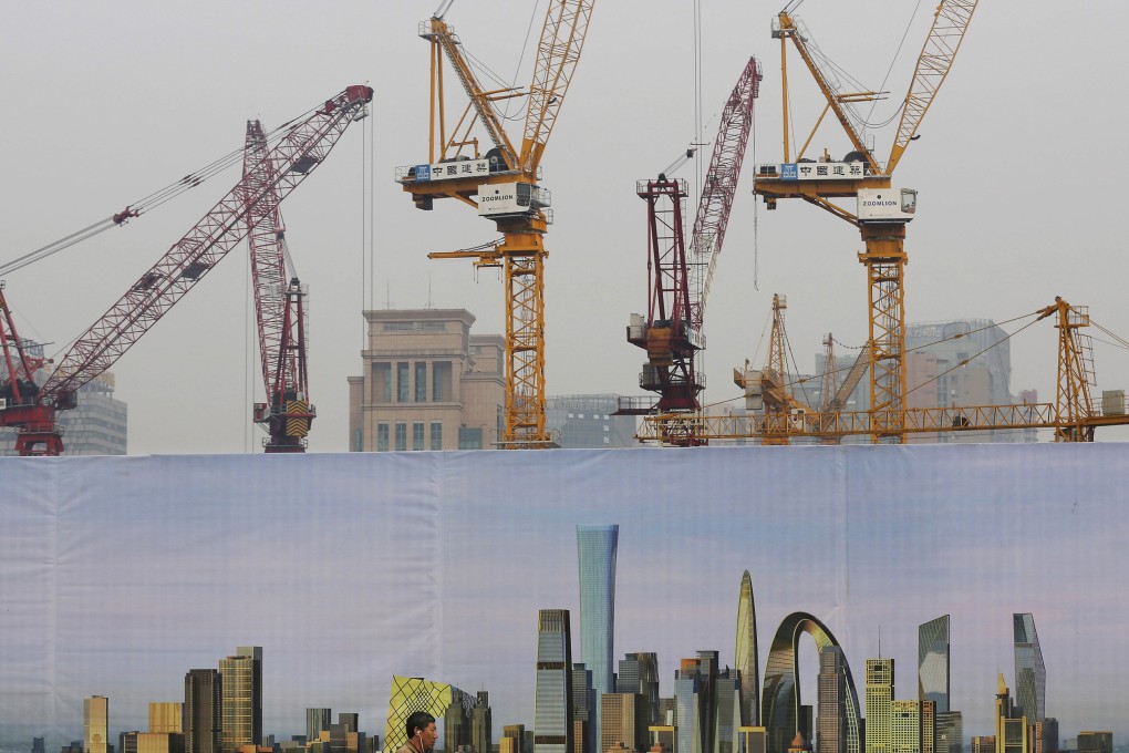 A man walks past a billboard display showing the scenic of Central Business District near a construction site in Beijing. Photo: AP