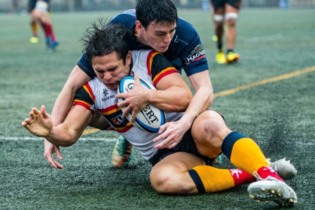 Rowan Varty gets across the line under pressure to score one of four HKCC tries in last weekend’s 34-19 romp over HK Scottish. Photos: HKRU