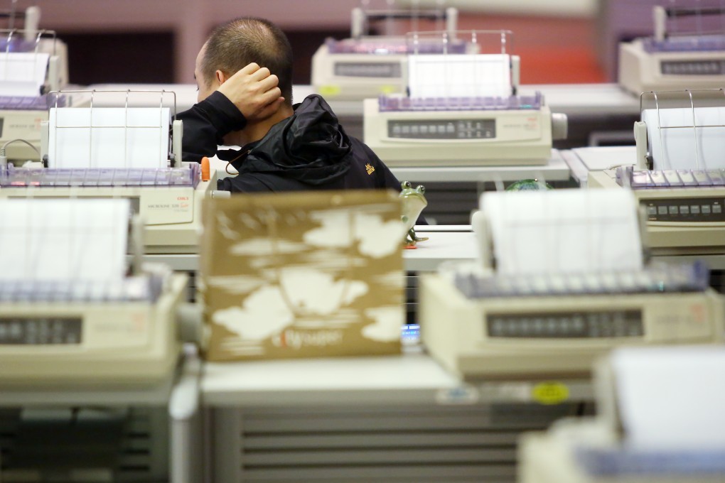 Floor traders in the Hong Kong Stock Exchange work on their orders. Photo: Sam Tsang