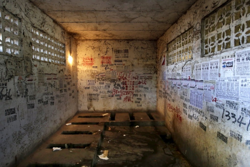 Posters, including those advertising treatments for sexually transmitted diseases, are stuck to the walls of a public toilet in a residential area for migrant workers in Shigezhuang village, Beijing. Photo: Reuters