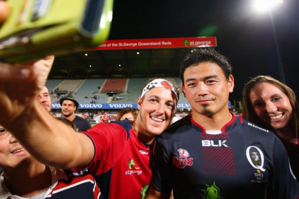Japanese import Ayumu Goromaru poses for photographs with Queensland Reds fans following a Super Rugby trial game between his new club and the Brumbies in Brisbane two weeks ago. Photo: AFP