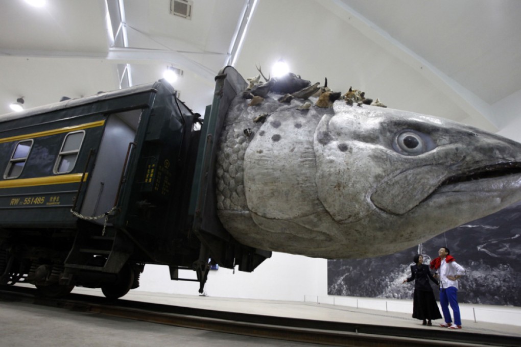 An installation art work entitled "Leviathanation" by Huang Yongping features a giant fish head made from fiberglass, stuffed animals and a train. Photo: AP