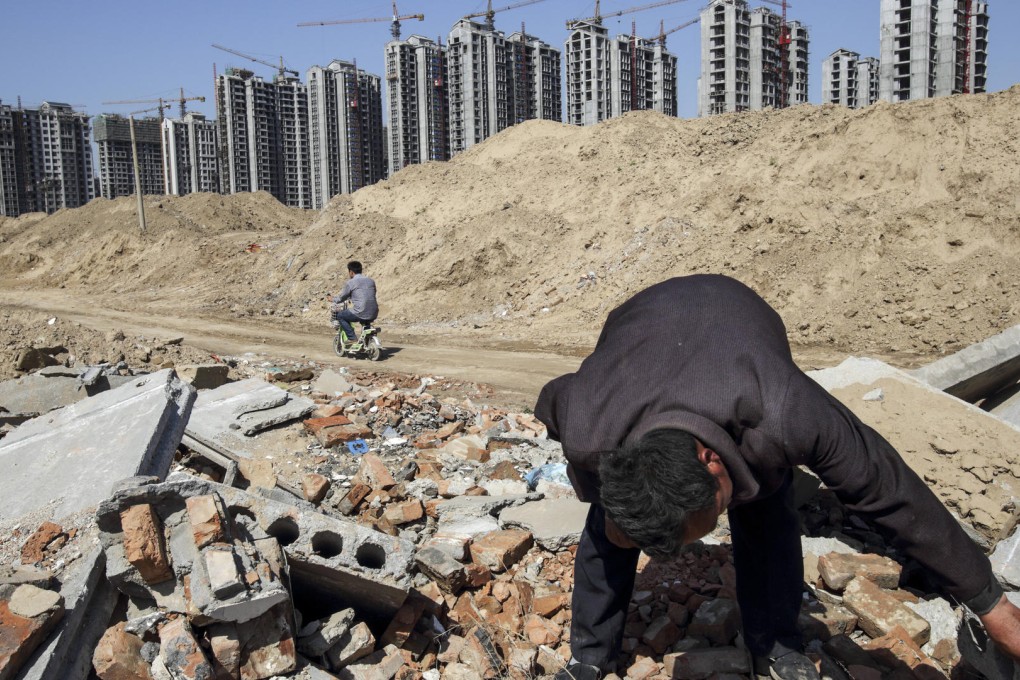 A 2013 image shows Li Rui scavenging for scrap metal where his village once was, in Liaocheng, Shandong province. Li was a farmer until six years ago, when the local government announced it would raze his village and turn farmland into an urban development zone.