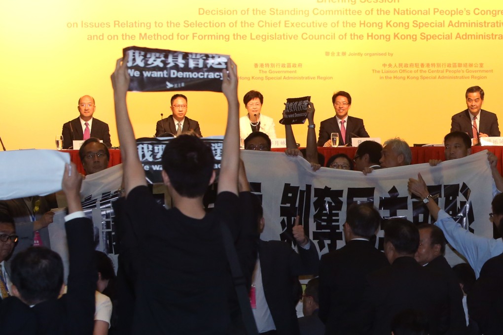 Pro-democracy lawmakers display placards against Li Fei during a briefing session at Asia World Expo in Chek Lap Kok in 2014. Photo: Sam Tsang