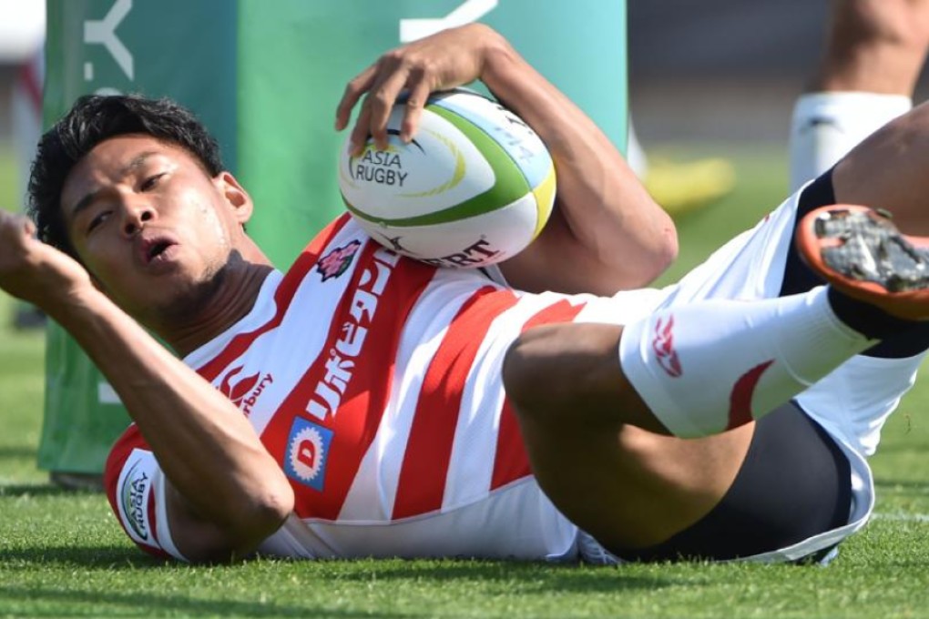 Japan fly-half Ryohei Yamanaka scores a try against South Korea during their 85-0 romp in the opening round of the 2016 Asia Rugby Championship in Yokohama on Saturday. Photos: AFP