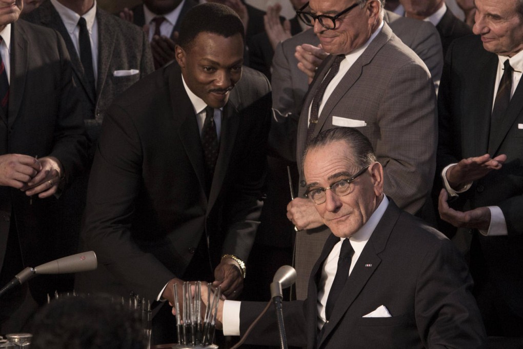 Martin Luther King (Anthony Mackie) shakes hands with Lyndon B. Johnson (Bryan Cranston, seated) in a still from All the Way.