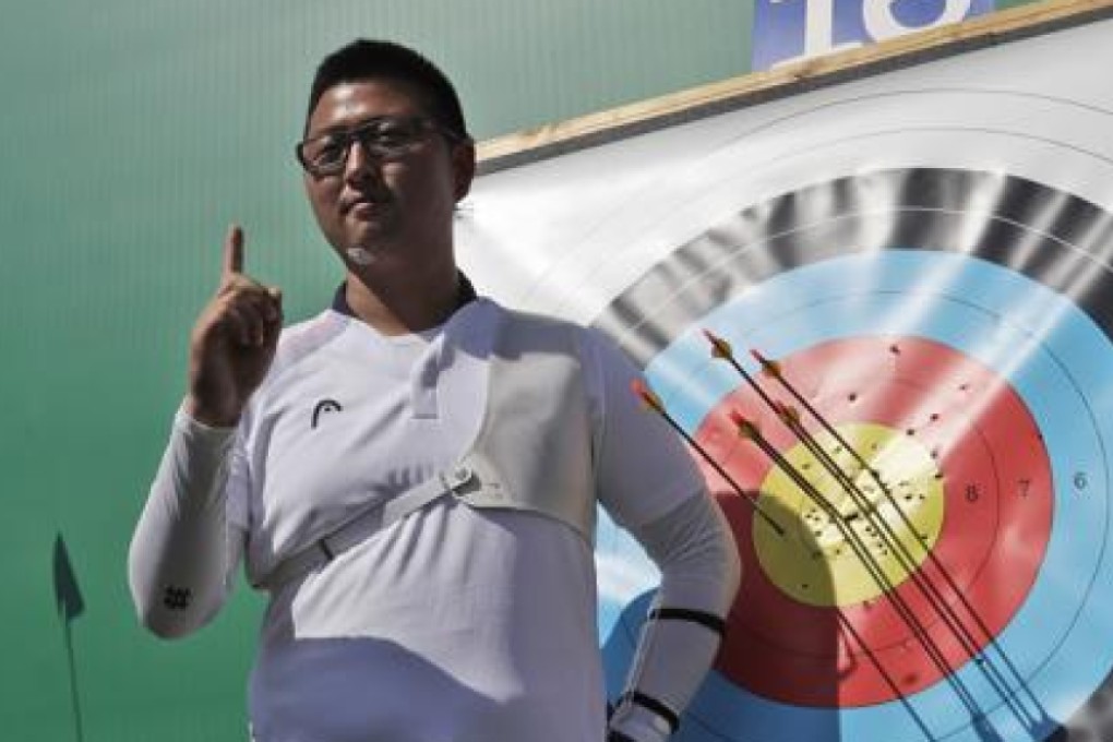 South Korean Kim Woo-jin poses for photographers after setting an archery world record during an individual ranking round on Friday ahead of the start of the 2016 Summer Olympics. Photo: AP