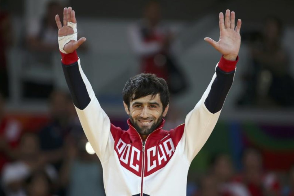 Russia’s Beslan Mudranov receives his 60kg judo gold medal in Rio on Saturday. Photos: Reuters