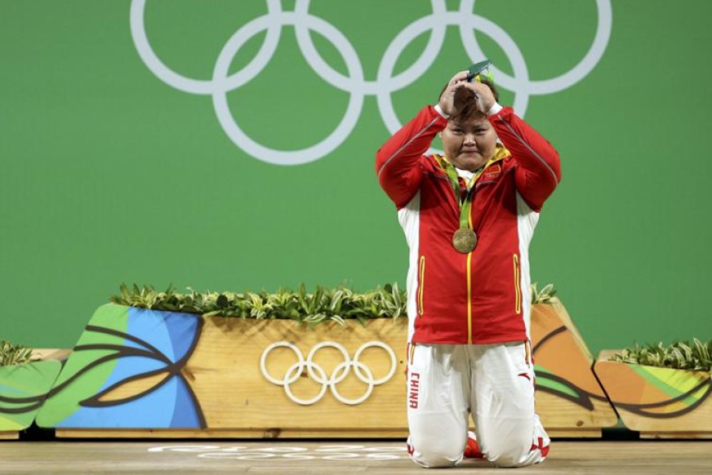 Meng Suping of China drops to her knees and bows to the crowd at Riocentro after receiving her gold medal in the women’s +75kg weightlifting competition. Photos: Reuters