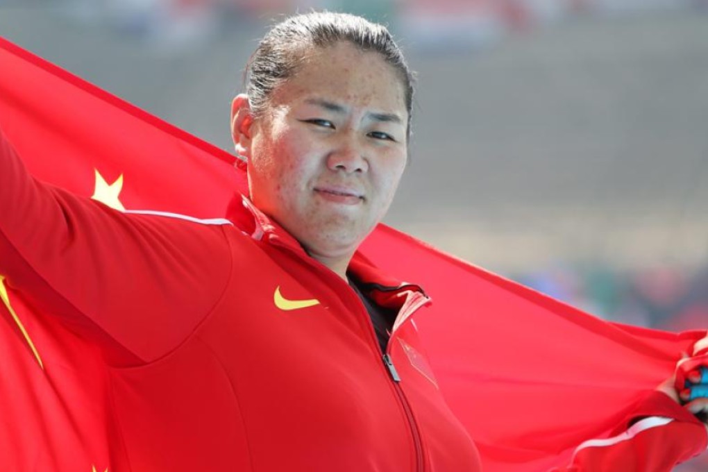Zhang Wenxiu wraps herself in the Chinese flag after placing second in the women’s hammer throw final at the Olympic Stadium in Rio de Janeiro on Monday. Photo: EPA