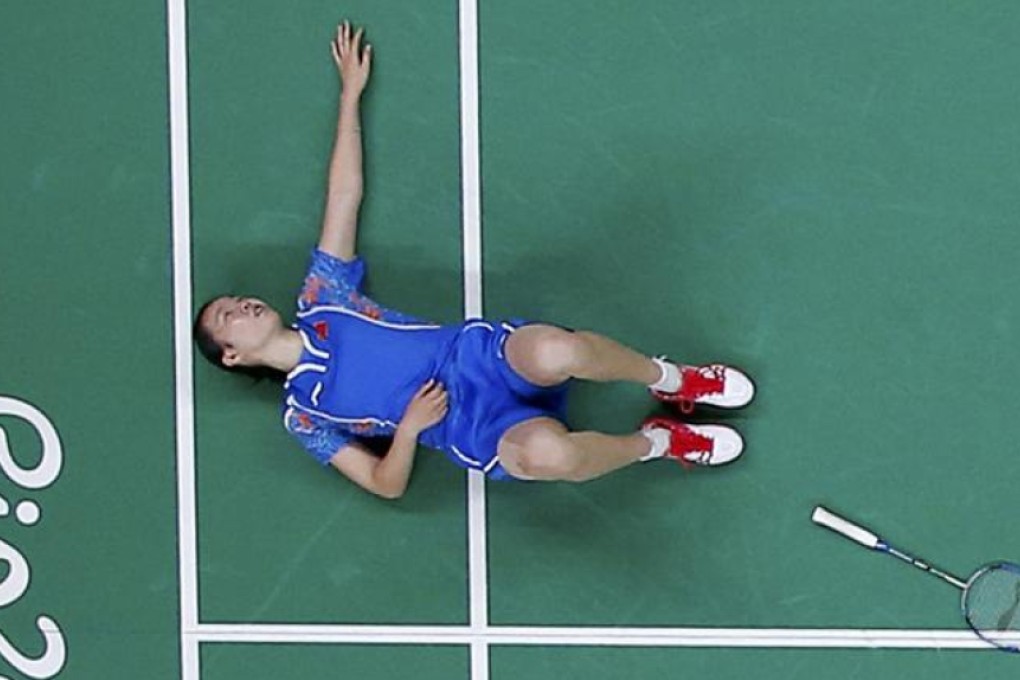 Li Xuerui of China lies on the court after sustaining an injury during her semi-final loss to world number one Carolina Marin of Spain. Photo: Reuters