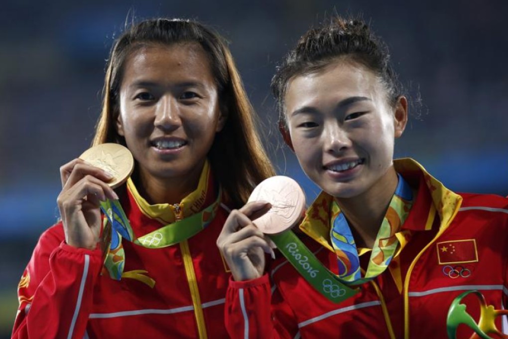 Chinese gold medallist Liu Hong (left) and bronze medallist Lu Ziuzhi on the podium after the women’s 20km race walk. Photo: EPA