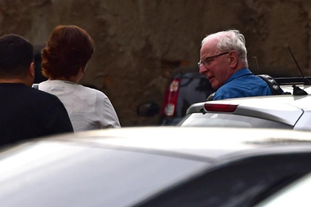 International Olympic Committee member Patrick Hickey (right) arrives at the police station after being arrested on allegations of taking part in a black market ticketing ring. Photos: AFP