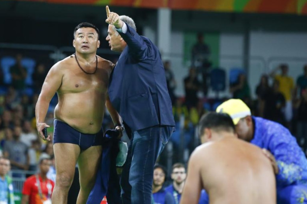 A coach for Mandakhnaran Ganzorig from Mongolia undresses in protest in front of judges after the wrestler’s loss in the men’s freestyle 65kg bronze medal bout on Sunday. Photo: Reuters