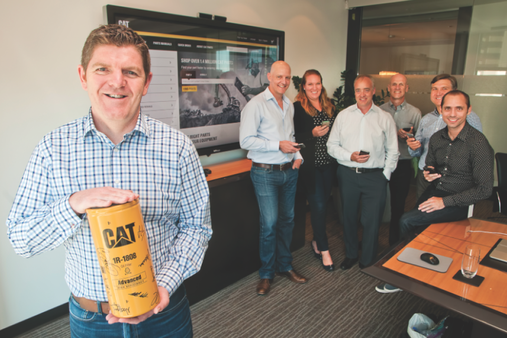 Finning Digital vice-president Gary Agnew holding the first item (an oil filter) to be ordered through its new e-commerces website (on the big screen). Photo: Chung Chow