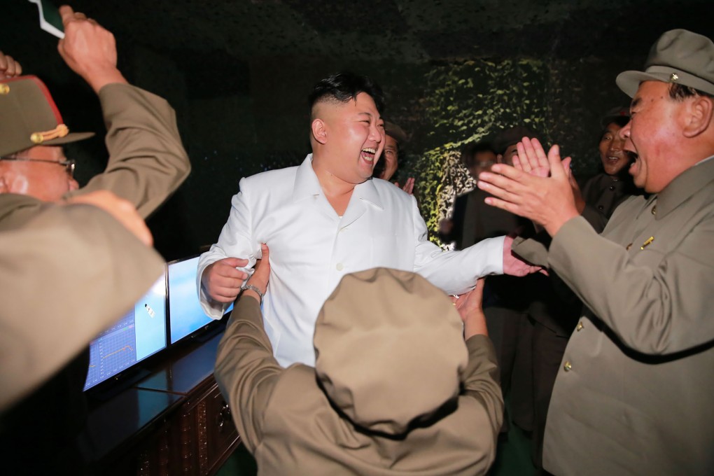 An undated picture released from North Korea's official Korean Central News Agency (KCNA) on August 25, 2016 shows North Korean leader Kim Jong-Un (C) laughing as he inspects a test-fire of strategic submarine-launched ballistic missile at an undisclosed location. Photo: KNS/AFP/Getty Images