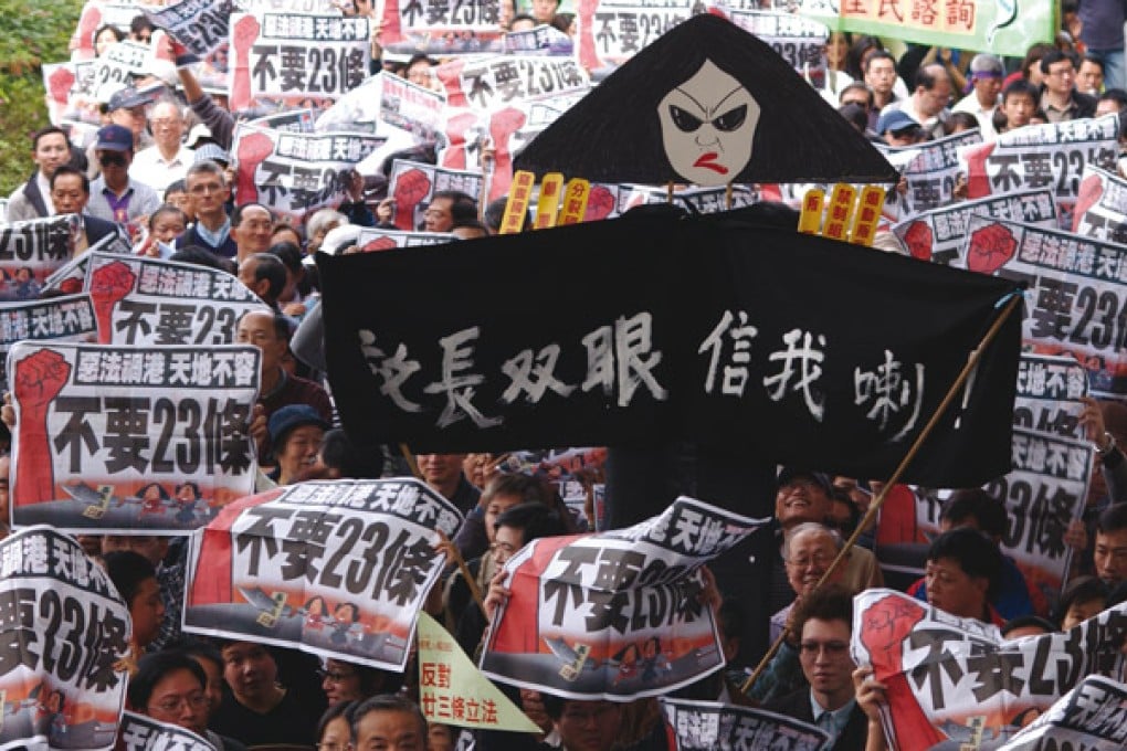 Protestors raise a Regina 'Broomhead' Ip effigy during the 2003 march