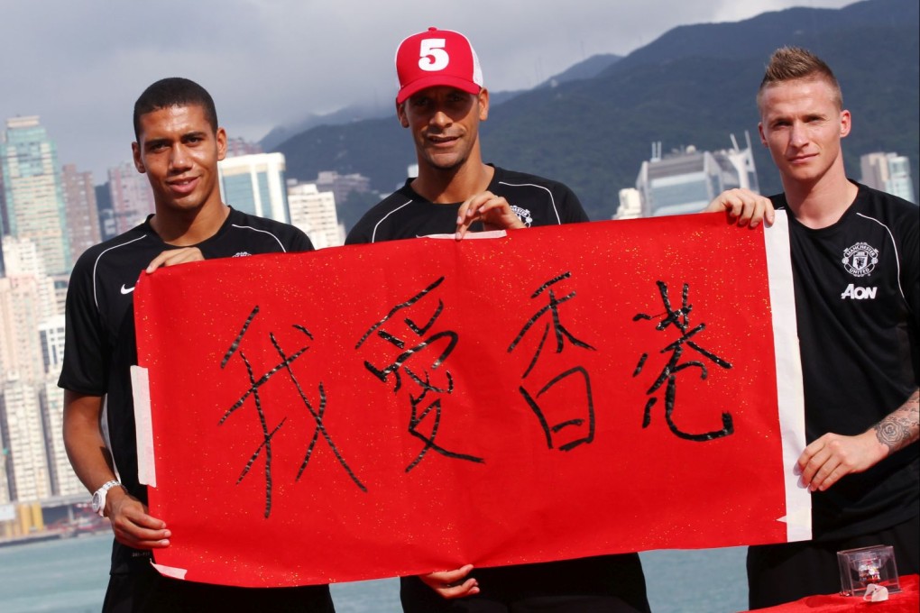 Manchester United players (L to R) Chris Smalling, Rio Ferdinand and Alexander Buttner write Chinese characters that read "I love Hong Kong." Photo: Nora Tam/SCMP