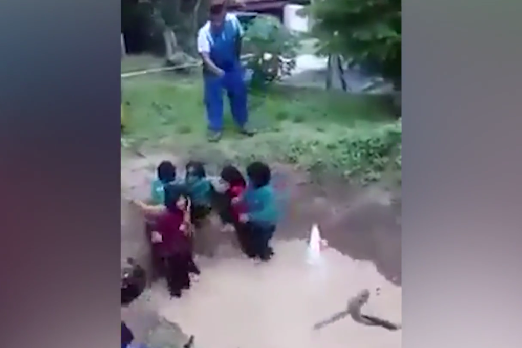 A still from the video which showed the girls sprayed with water if they tried to escape the muddy pit when live snakes were thrown in. Photo: The Star